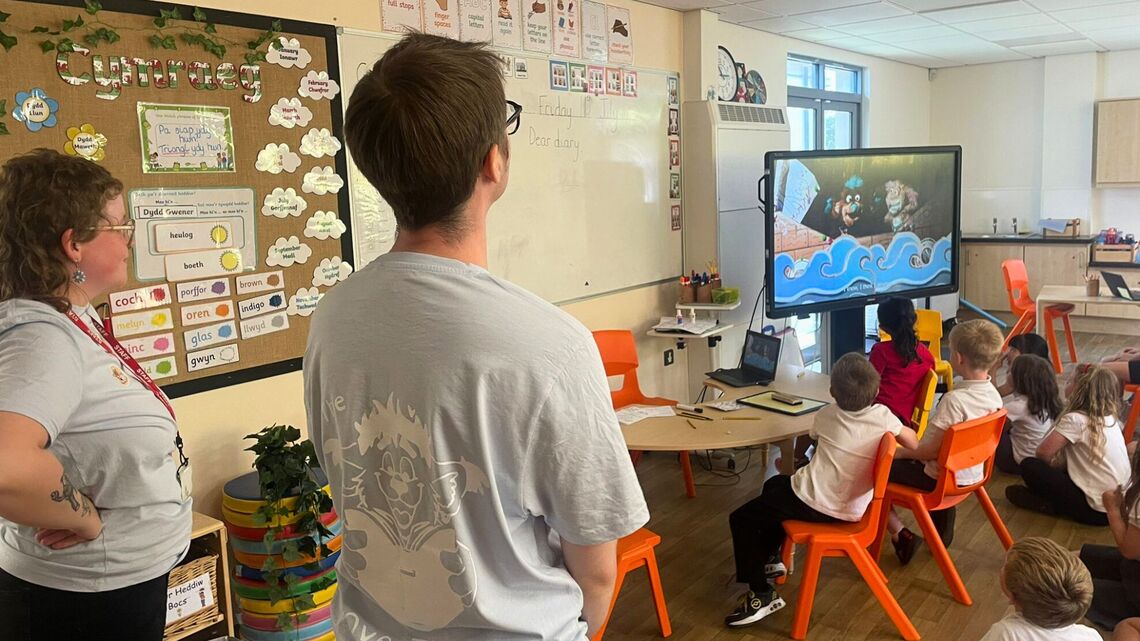 The OverThere&#39;s cast watch on as a class of primary school children watch a video featuring puppets